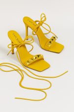 صندل نسائي أصفر، صندل نسائي، كعب عالي، صندل بكعب ورباط، صندل بكاحل، صندل بمسامير ذهبية، صندل عصري، صندل لمناسبات، صندل CAFE ROBERN، صندل مفتوح مقدمة مربعة