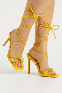 صندل نسائي أصفر بكعب عالي، رباط كاحل ومسامير ذهبية من Cape Robbin، تصميم متوازن يجمع بين العملية والجاذبية البصرية 2 WhatsApp Image 2025 07 30 at 12.07.13 PM 1