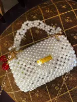 شنطة لولي بيضاء أنيقة مصنوعة من الخرز اللامع عالي الجودة، بتصميم عصري فاخر يناسب جميع الإطلالات. تتميز بمقبض وسلسلة أنيقة يمكن حملها يدويًا أو على الكتف، مثالية للحفلات، السهرات، والمناسبات الخاصة. حقيبة تجمع بين البساطة والفخامة وتضفي لمسة راقية على فستان السهرة أو الإطلالة اليومية الأنيقة. - الصورة 3
