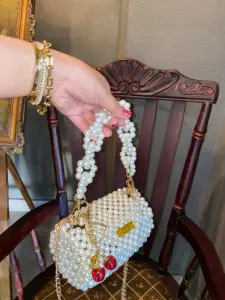 شنطة لولي بيضاء أنيقة مصنوعة من الخرز اللامع عالي الجودة، بتصميم عصري فاخر يناسب جميع الإطلالات. تتميز بمقبض وسلسلة أنيقة يمكن حملها يدويًا أو على الكتف، مثالية للحفلات، السهرات، والمناسبات الخاصة. حقيبة تجمع بين البساطة والفخامة وتضفي لمسة راقية على فستان السهرة أو الإطلالة اليومية الأنيقة. 3 WhatsApp Image 2025 08 28 at 6.02.41 PM 1