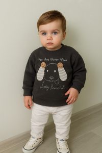 سويت شيرت رمادي غامق للأطفال بتصميم وجه كلب ثلاثي الأبعاد وعبارة You Are Never Alone، طقم مريح وعصري 1 WhatsApp Image 2025 10 22 at 1.03.13 PM
