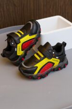 حذاء رياضي أطفال أسود بتفاصيل حمراء وصفراء، تصميم عصري