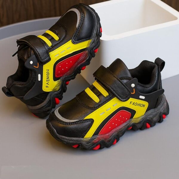 حذاء رياضي أطفال أسود بتفاصيل حمراء وصفراء، تصميم عصري