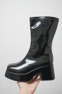 بوت نسائي أسود لامع بكعب عريض ومنصة مرتفعة، تصميم أنيق مستوحى من موضة السبعينات، مثالي للمناسبات، السهرات، والإطلالات العصرية الأنيقة 1 WhatsApp Image 2025 10 29 at 10.18.07 AM 3