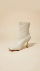 بوت نسائي أوف وايت بكعب متوسط، جلد صناعي فاخر بتصميم أنيق وعصري، مثالي للمناسبات الرسمية أو الإطلالات اليومية الراقية 1 WhatsApp Image 2025 11 01 at 10.05.03 AM 1