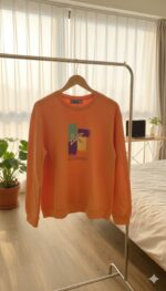 سويتشيرت نسائي قطن خفيف بلون برتقالي زاهي بطبعة عصرية ملونة