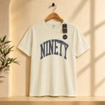 تيشرت رجالي بيج فاتح مطبوع بتصميم كلمة "NINETY" من RGB BASICS